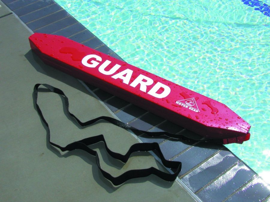 A+lifeguard+rescue+tube+laying+on+pool+deck.+A+popular+summer+job+for+students+is+lifeguarding+at+an+outdoor+pool.