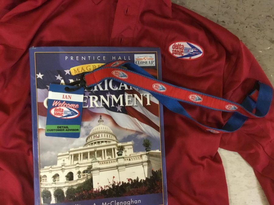 A Delta Sonic work uniform and name tag placed on a Government textbook. Students often change their uniforms in the bathrooms after school. 
