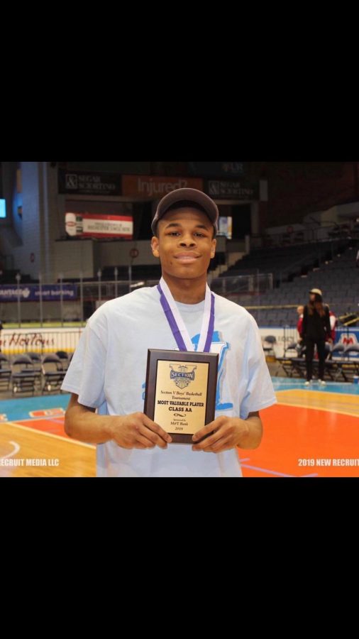 Junior guard Jermaine Taggart holds MVP award after championship game in Blue Cross Arena. 