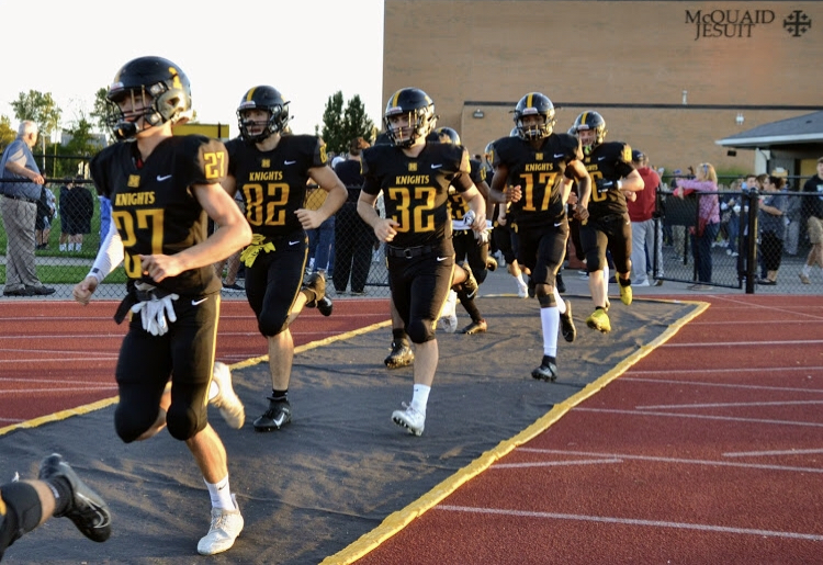 The Knights run onto the field before their 28-0 victory over Pittsford.
