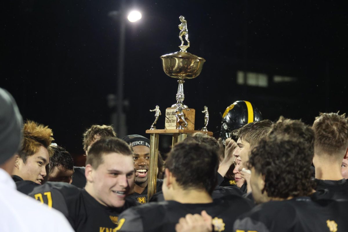 McQuaid+hoists+the+trophy+after+defeating+Aquinas+Institute+on+Oct.+21.+